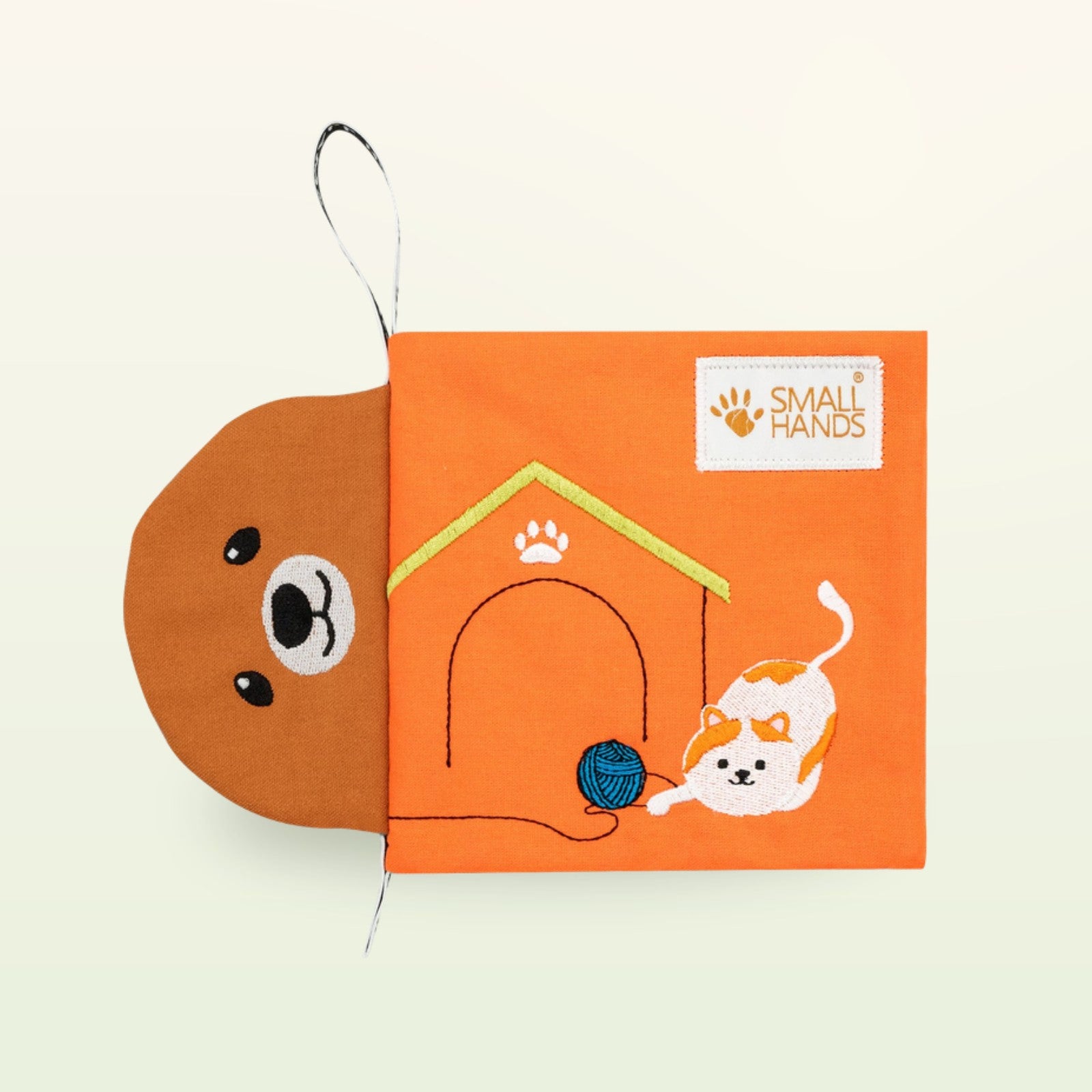 Small Hands Haustiere Montessori Stoffbuch – oranger Einband mit Hundegesicht, Hündehütte und spielender Katze auf sanftem Creme-Hintergrund – ab 0 Monaten