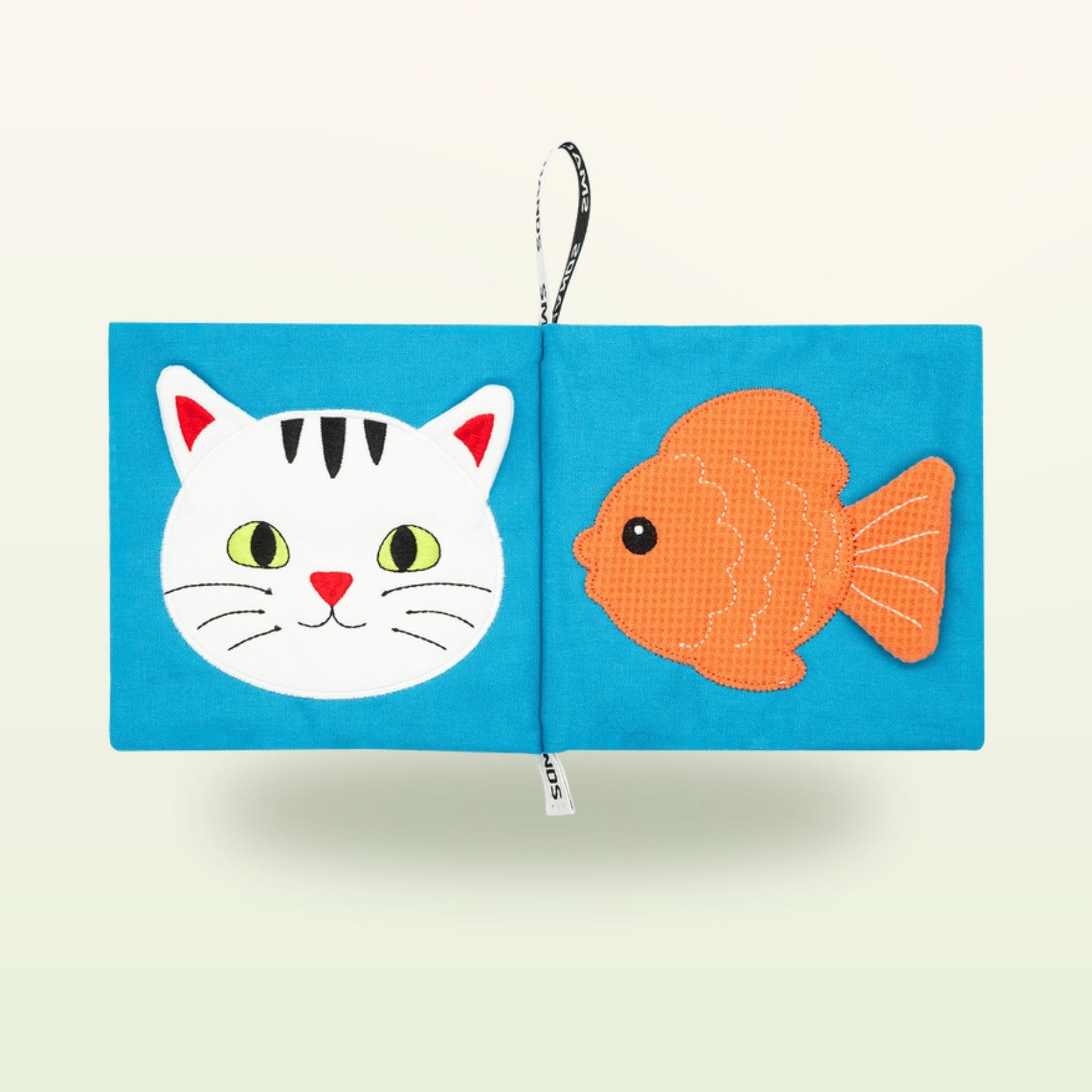 Small Hands Haustiere Montessori Stoffbuch aufgeschlagen – Katzengesicht und Goldfisch auf sanftem Creme-Hintergrund – ab 0 Monaten