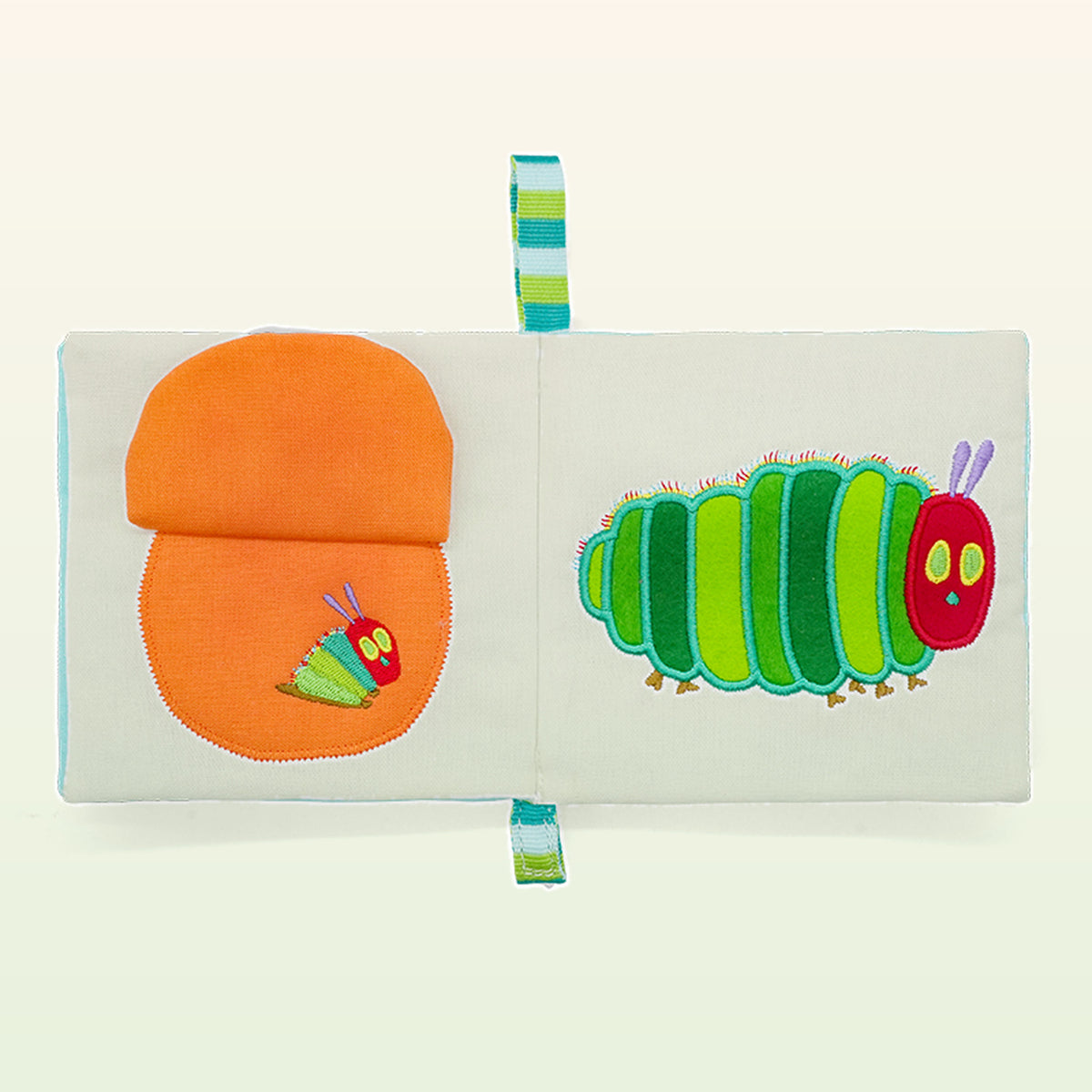 Small Hands Die Raupe Nimmersatt Montessori Stoffbuch aufgeschlagen – orange Frucht zum Aufklappen und große gestickte Raupe – ab 0 Monaten