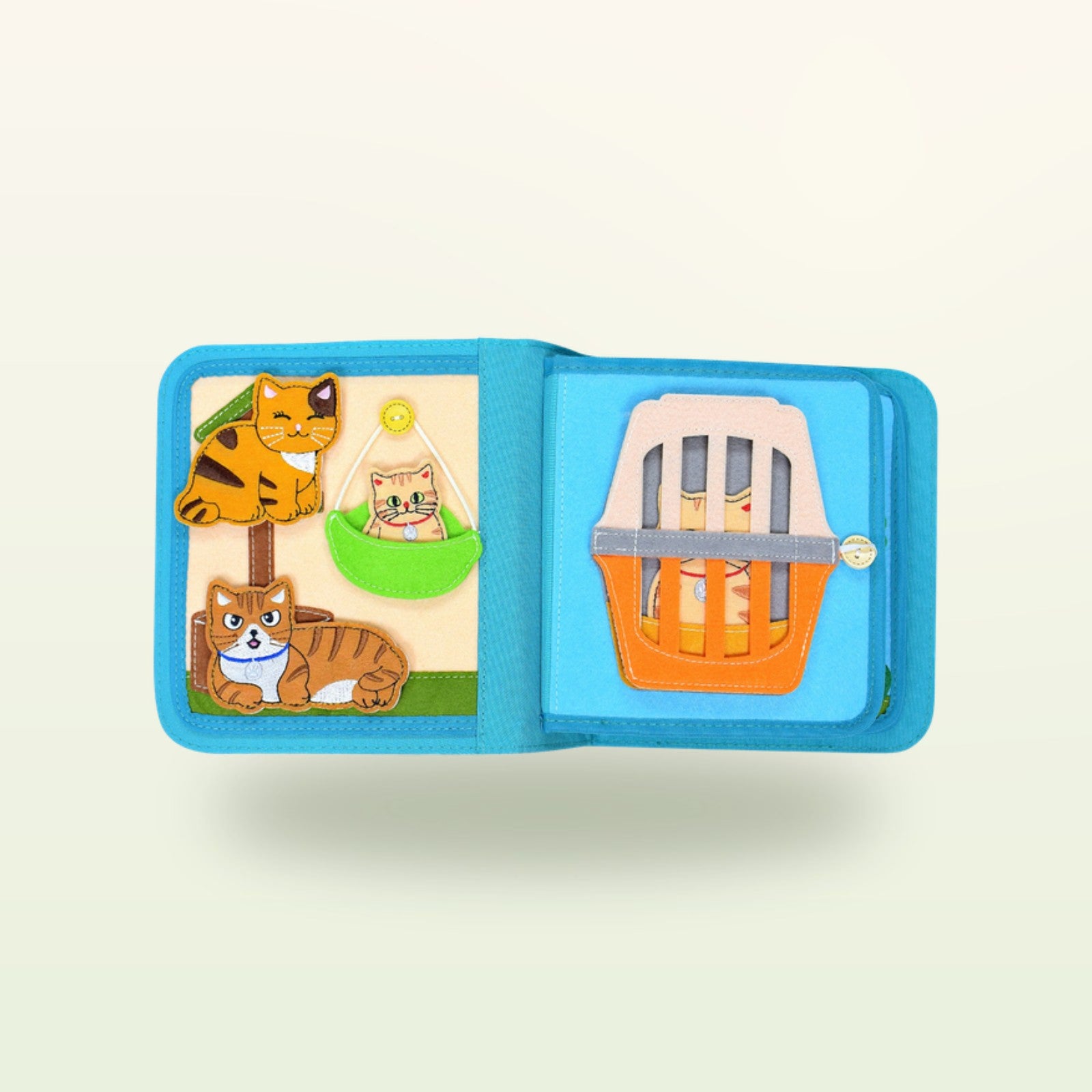 Glückliche Katze Quiet Book Seite mit Kätzchen am Baum und oranger Transportbox auf sanftem Creme-Hintergrund – ab 1 Jahr