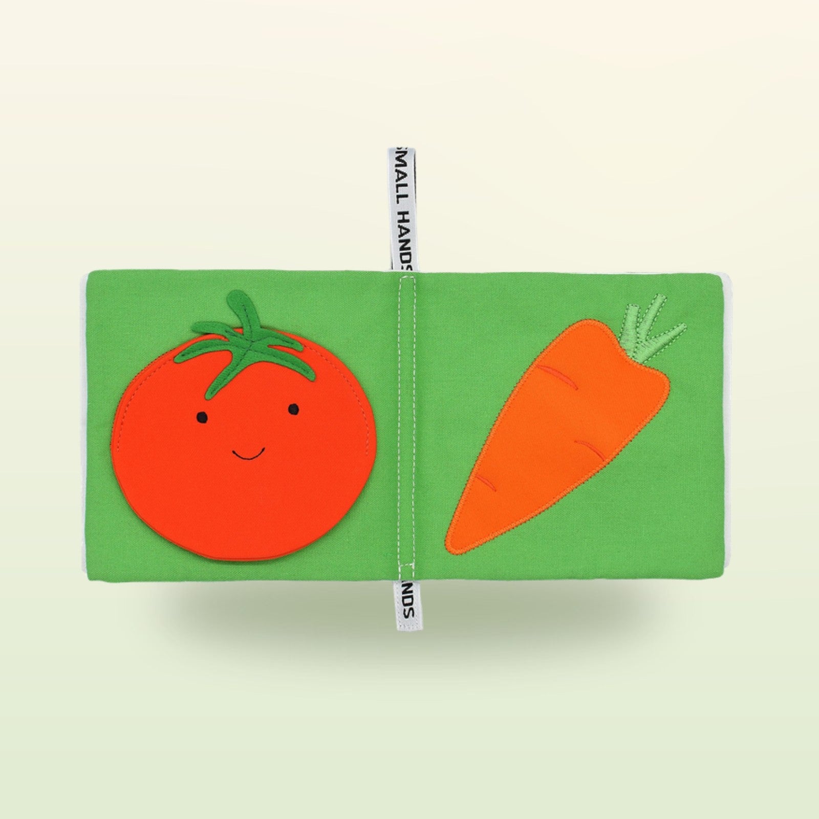 Small Hands Gemüse Montessori Stoffbuch Doppelseite mit Tomate und Karotte auf sanftem Wiesengrün-Hintergrund – ab 1 Jahr
