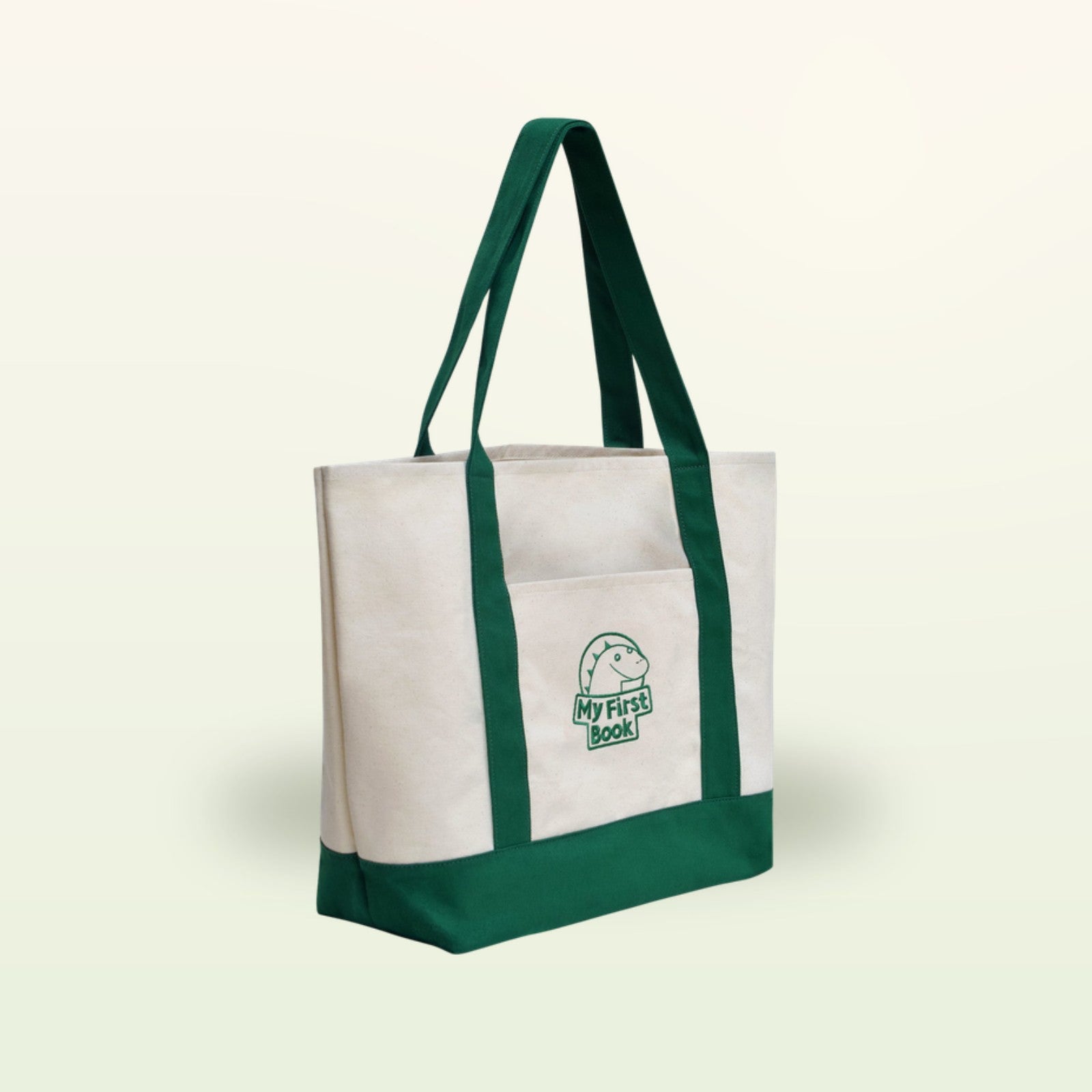 My First Book Tragetasche – cremefarbene Stofftasche mit grünen Henkeln auf sanftem Creme-Hintergrund