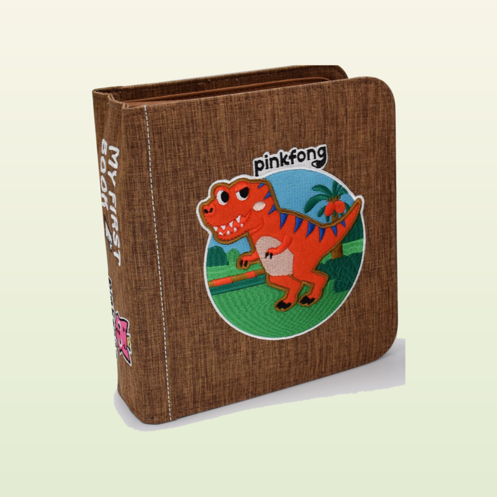 T-Rex Quiet Book geschlossen – braunes MY-FIRST-BOOK-Cover mit orangem Dino-Motiv auf sanftem Dschungelgrün-Hintergrund